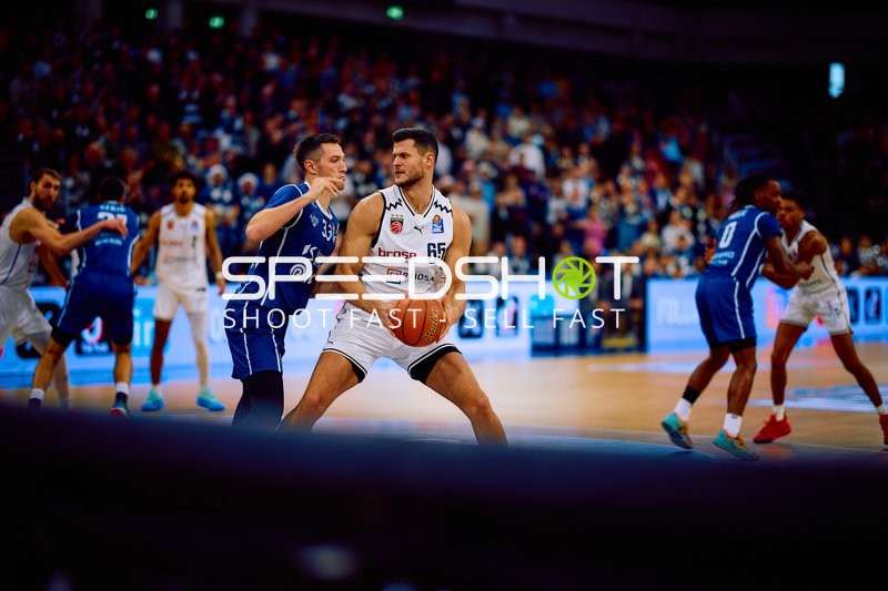 Filip Stanic von Brose Bamberg dribbelt den Ball aggressiv, während er von einem Verteidiger der MLP Academics Heidelberg bedrängt wird.