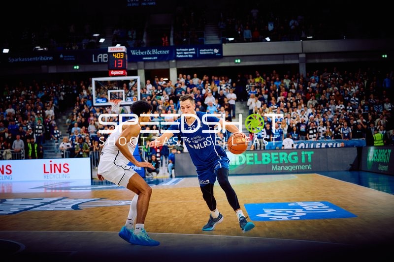 Ryan Mikesell von MLP Academics Heidelberg dribbelt den Ball gegen einen Verteidiger von Brose Bamberg.