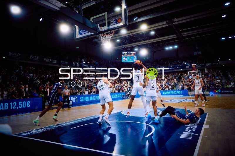 Ein Spieler von MLP Academics Heidelberg geht zum Korb während ein Spieler am Boden liegt.