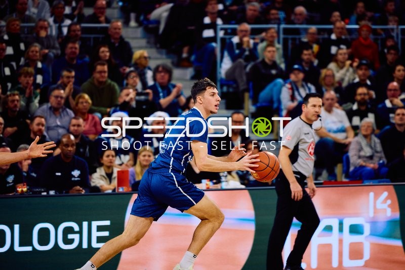 Ein Basketballspieler dribbelt den Ball auf dem Spielfeld.