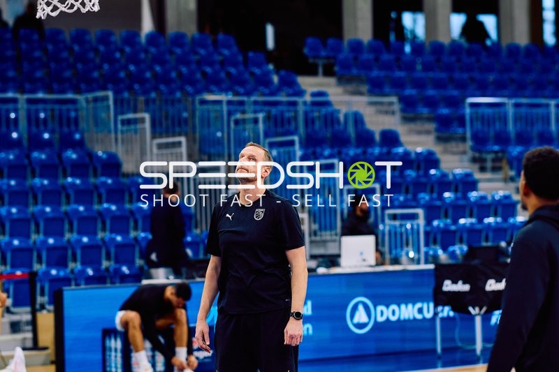 Ein Trainer oder Offizieller steht nachdenklich auf dem Spielfeld.