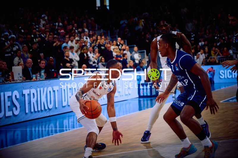 Ein Spieler der MLP Academics Heidelberg dribbelt den Ball, während ein Spieler von Brose Bamberg verteidigt.