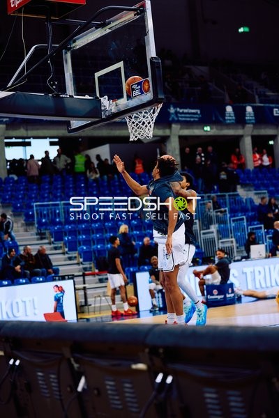 Ein Spieler versucht, einen Korbleger zu machen, während ein anderer Spieler ihn verteidigt.