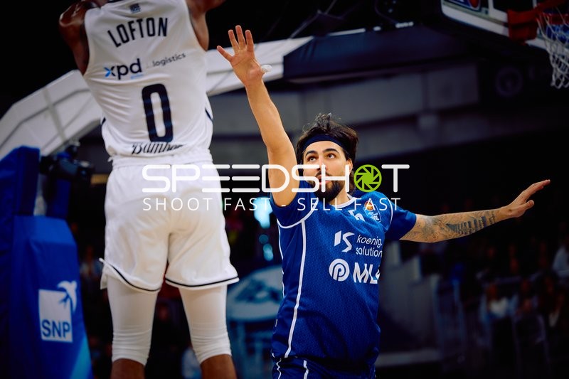 Ein Spieler von Brose Bamberg führt einen Sprungwurf aus, während ein Spieler der MLP Academics Heidelberg verteidigt.