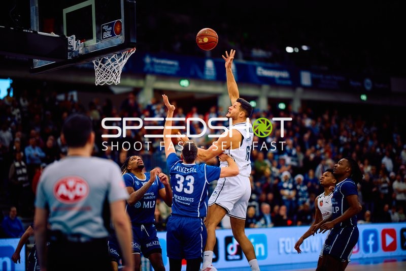 Ein Spieler versucht einen Wurf am Korb während eines Basketballspiels.