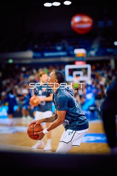 Ein Basketballspieler bereitet sich mit einem Ballwurf auf das Spiel vor.