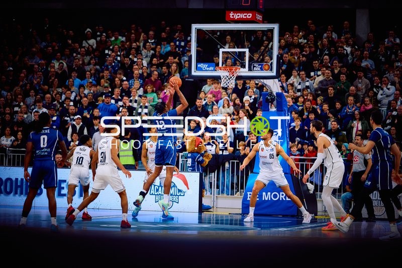 Ein Spieler von Brose Bamberg mit der Nummer 12 wirft den Ball in Richtung Korb.