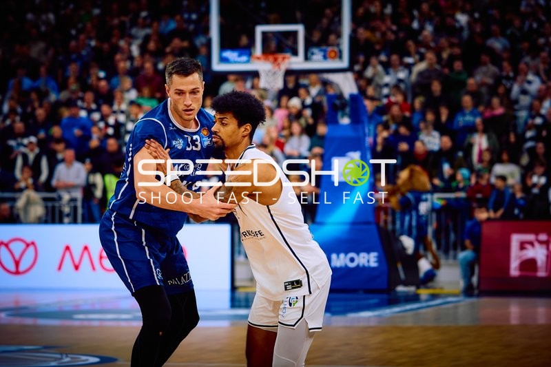 Zweikampf zwischen Spielern während eines Basketballspiels.