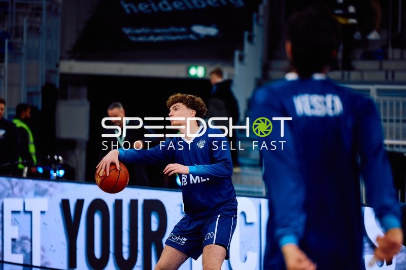 Ein Spieler der MLP Academics Heidelberg wärmt sich mit einem Basketball auf.
