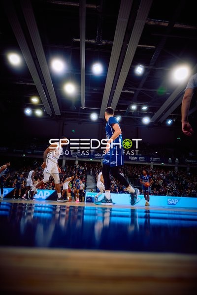 Spielszene auf dem Basketballfeld mit Spielern im Fokus.