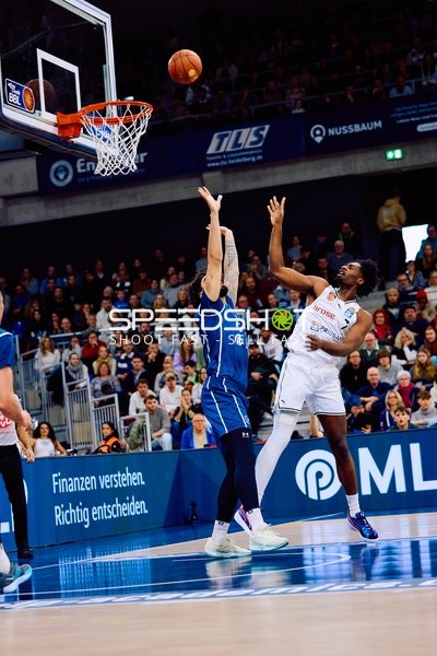 Ein Spieler von Brose Bamberg versucht, einen Korbleger zu blockieren, während ein Spieler der MLP Academics Heidelberg den Ball auf den Korb wirft.