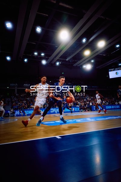 Ein Spieler von MLP Academics Heidelberg dribbelt den Ball, während ein Spieler von Brose Bamberg verteidigt.