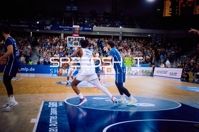 Ein Spieler von MLP Academics Heidelberg dribbelt den Ball und wird von einem Spieler von Brose Bamberg verteidigt.