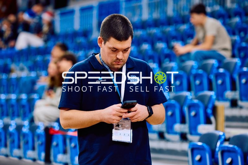 Eine Person steht alleine und schaut auf sein Handy.