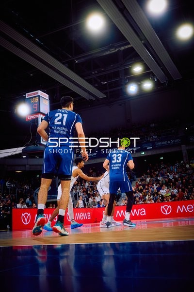 Spieler in einem Spielsituation auf dem Basketballfeld.