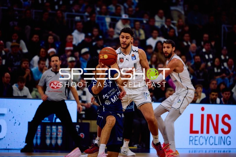 Ein Spieler von MLP Academics Heidelberg versucht, den Ball zu halten, während Brandon Horvath von Brose Bamberg verteidigt.