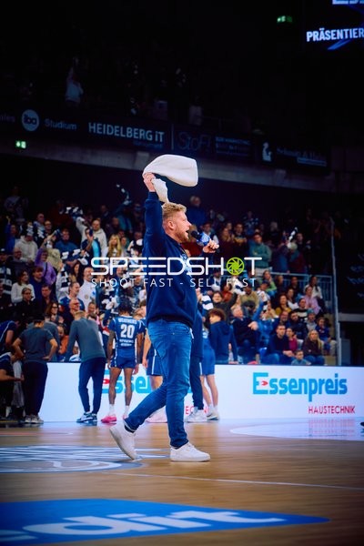 Ein Mann schwenkt ein Handtuch auf dem Spielfeld.