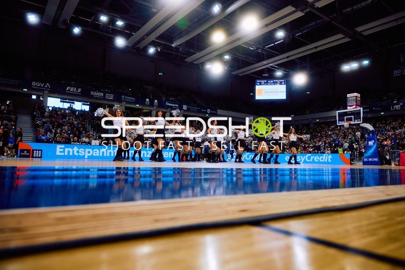 Cheerleader-Gruppe tanzt auf dem Basketballfeld.