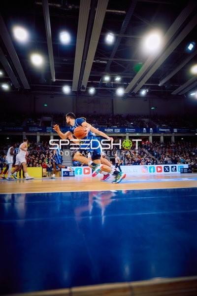 Ein Spieler dribbelt den Ball in Richtung des Korbes.