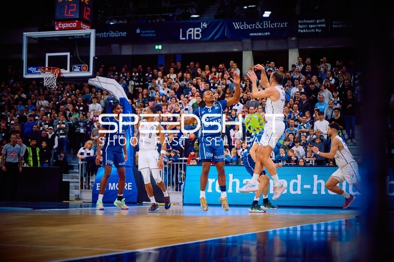 Ein Spieler von Brose Bamberg versucht einen Sprungwurf, während die MLP Academics Heidelberg verteidigen.