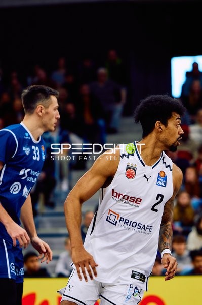 Ein Spieler von Brose Bamberg mit der Nummer 2 beobachtet das Spielgeschehen, während ein Spieler von MLP Academics Heidelberg mit der Nummer 33 in der Nähe ist.