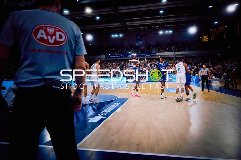 Ein Basketballspiel im Gange mit Spielern auf dem Spielfeld.