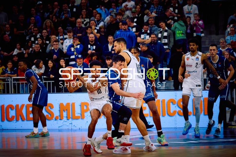 Ein Spieler von Brose Bamberg hält den Ball, während ein Spieler von MLP Academics Heidelberg verteidigt.