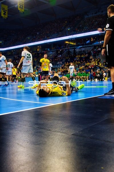 Ein Spieler von Rhein Neckar Löwen liegt auf dem Boden, während das Spiel pausiert ist.