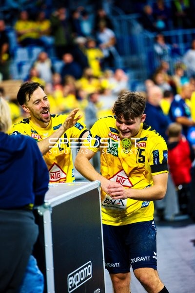 Spieler von Rhein Neckar Löwen feiern am Spielfeldrand.