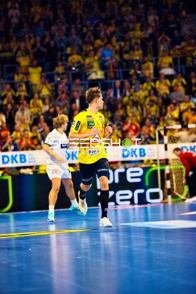Ein Spieler von Rhein Neckar Löwen hält den Ball auf dem Spielfeld.