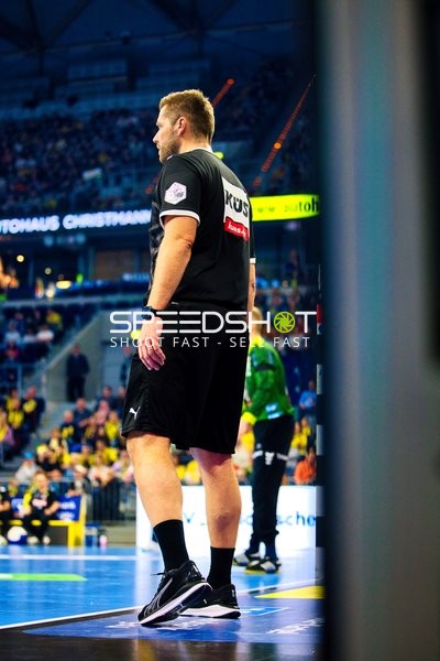 Ein Trainer oder Offizieller steht am Spielfeldrand.