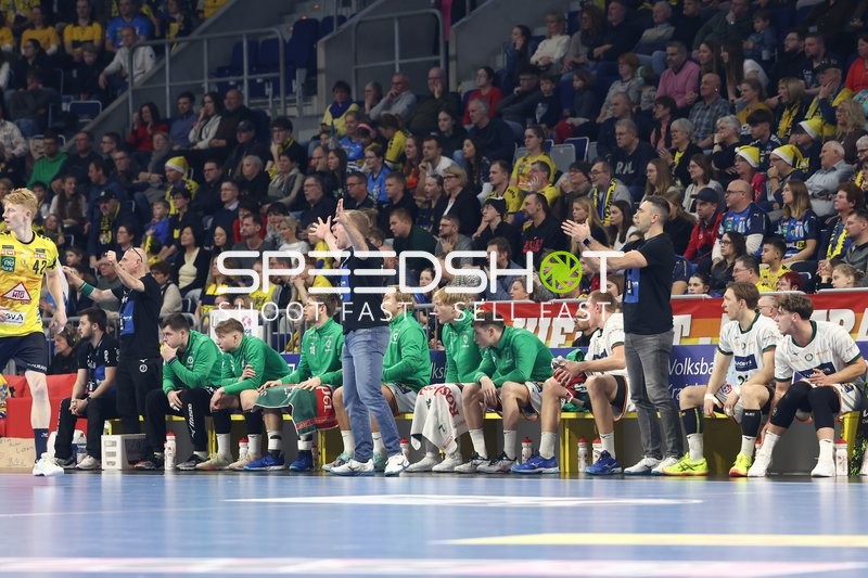 Teams beobachten das Spiel von der Seitenlinie