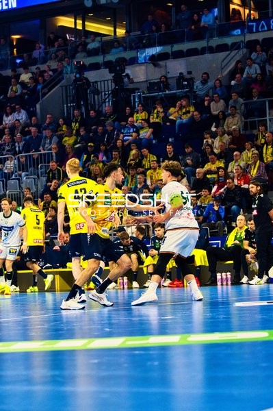 Ein Spieler von Rhein Neckar Löwen versucht, den Ball zu passen, während er von einem HSG Wetzlar Spieler bedrängt wird.