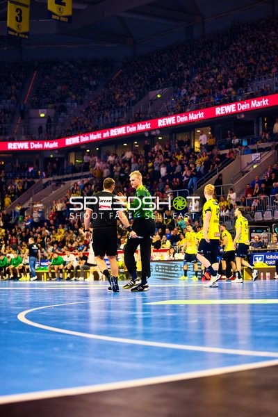 Ein Schiedsrichter unterhält sich mit einem Spieler auf dem Spielfeld.