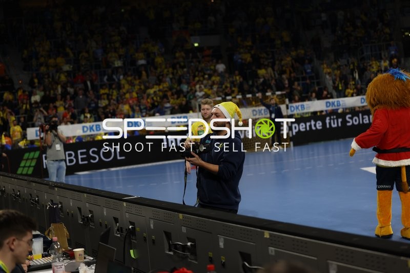 Moderator spricht mit einem Mikrofon zu den Zuschauern.