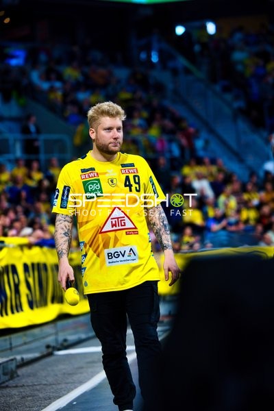 Ein Spieler von Rhein Neckar Löwen steht am Spielfeldrand.