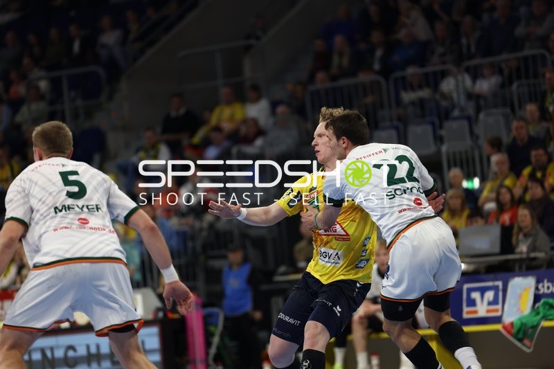 Ein Spieler der Rhein Neckar Löwen versucht, an zwei Verteidigern von HSG Wetzlar vorbeizukommen.