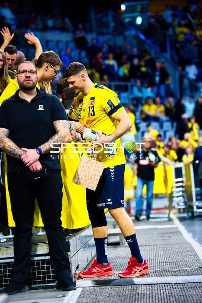 Ein Spieler von Rhein Neckar Löwen interagiert mit Fans und hält eine Geschenktüte.