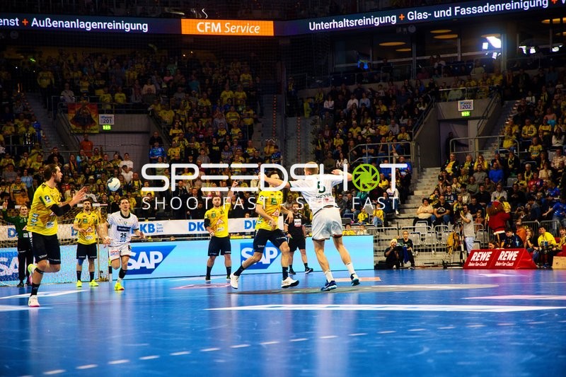 Ein Spieler von Rhein Neckar Löwen wirft den Ball in Richtung Tor, während ein Spieler von HSG Wetzlar versucht zu blocken.