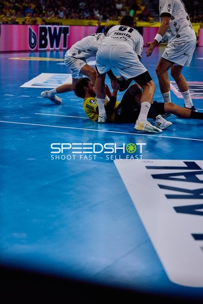 Kampf um den Handball auf dem Boden zwischen den Spielern.