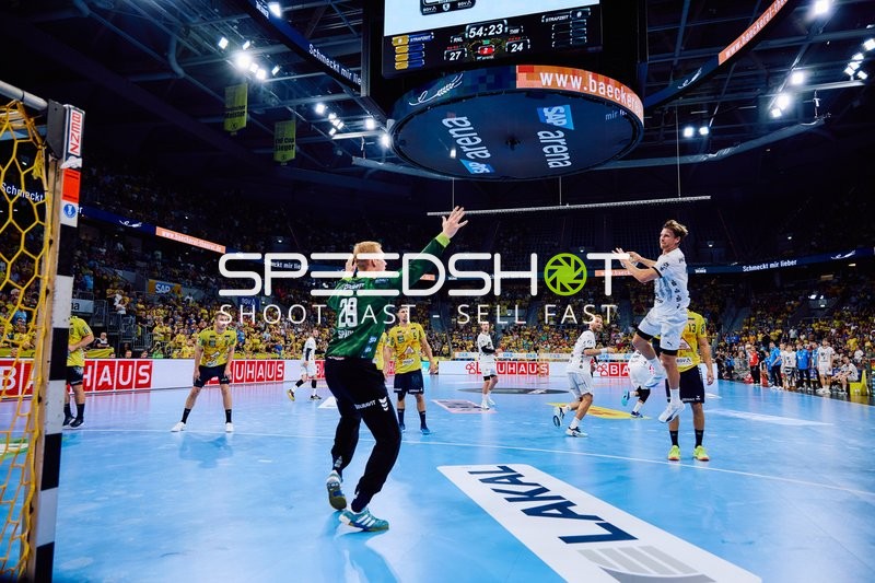 Ein Spieler von THW Kiel springt zum Wurf, während der Torwart von Rhein Neckar Löwen bereit ist, den Ball abzuwehren.