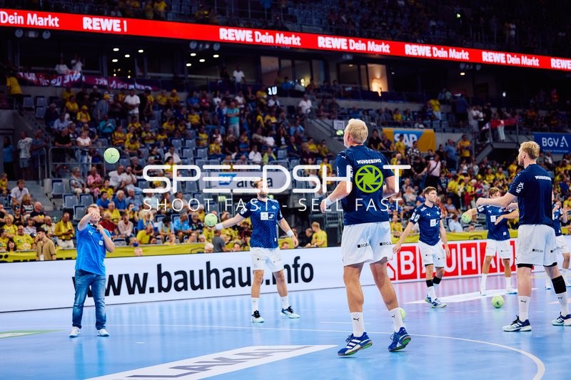 Spieler von THW Kiel wärmen sich auf dem Spielfeld auf.