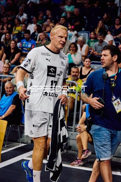 Ein Spieler von THW Kiel steht an der Seitenlinie und spricht mit einem Offiziellen.