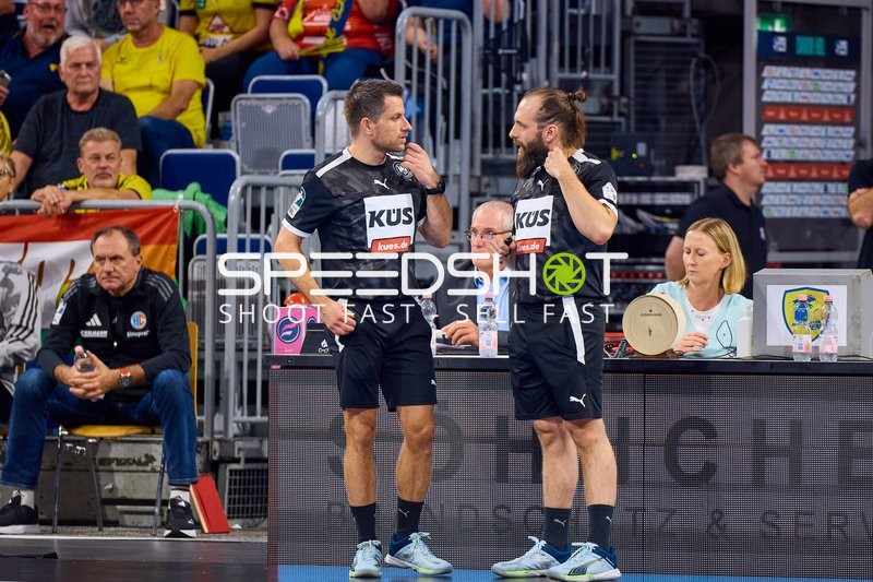 Besprechung zwischen Offiziellen oder Trainern am Spielfeldrand.