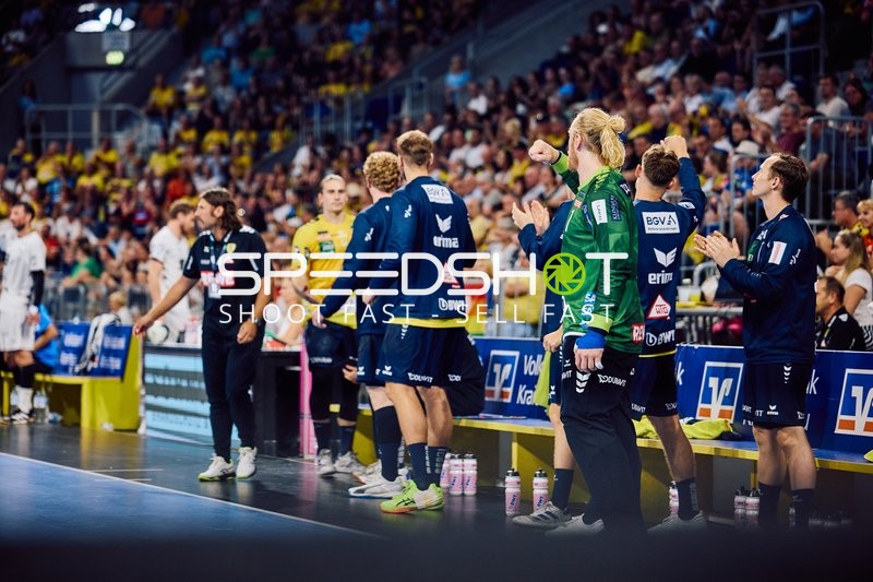 Spieler auf der Bank von Rhein Neckar Löwen und THW Kiel während des Spiels.