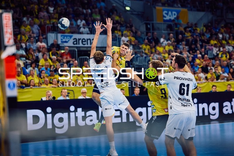 Ein Spieler der Rhein Neckar Löwen versucht, den Ball über die Verteidigung von THW Kiel zu werfen.
