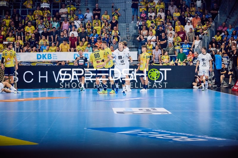 Spieler von Rhein Neckar Löwen und THW Kiel sind auf dem Spielfeld in Aktion.