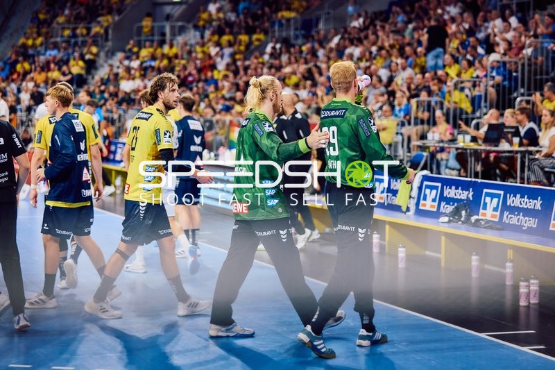 Spieler beider Teams verlassen das Spielfeld nach dem Match.