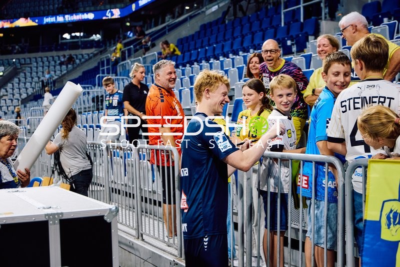 Ein Spieler von Rhein Neckar Löwen gibt Autogramme an Fans.