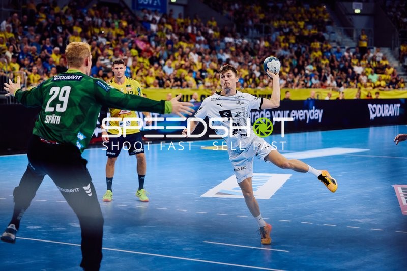 Ein Spieler von THW Kiel, Bence Imre, ist im Angriff, während der Torhüter von Rhein Neckar Löwen bereit ist zu parieren.